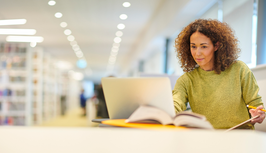 Inside Higher Ed Report Spotlights Education Pathways for Older Learners woman on laptop in library