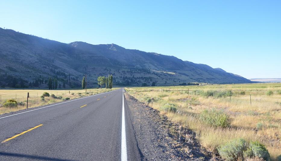 Wide open highway with mountains in distance  Wide open highway with mountains in distance