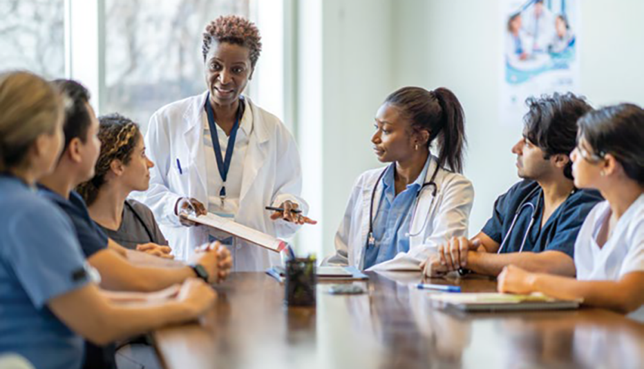 doctor teaching students at a large table