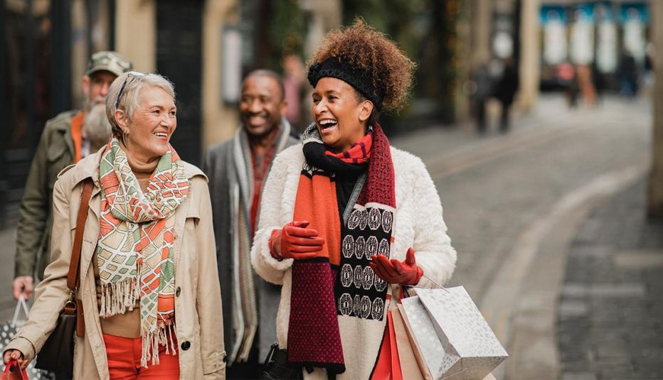 Group of adults enjoying a day out together. They are walking down a city street as they do their Christmas shopping.