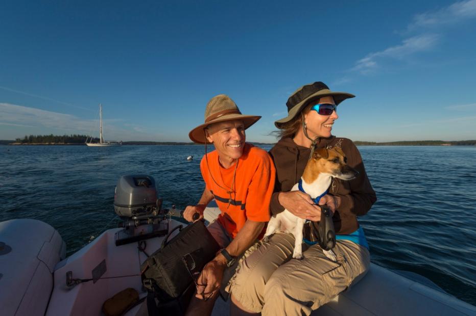Active seniors taking a dinghy to shore from their sailboat.