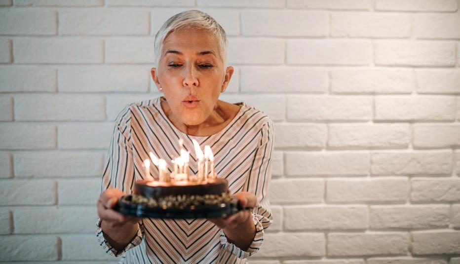 Older woman blowing out birthday candles