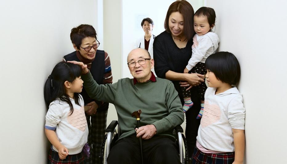 Hospital discharge for home treatment. Family warmly celebrates. Doctor relieved behind.