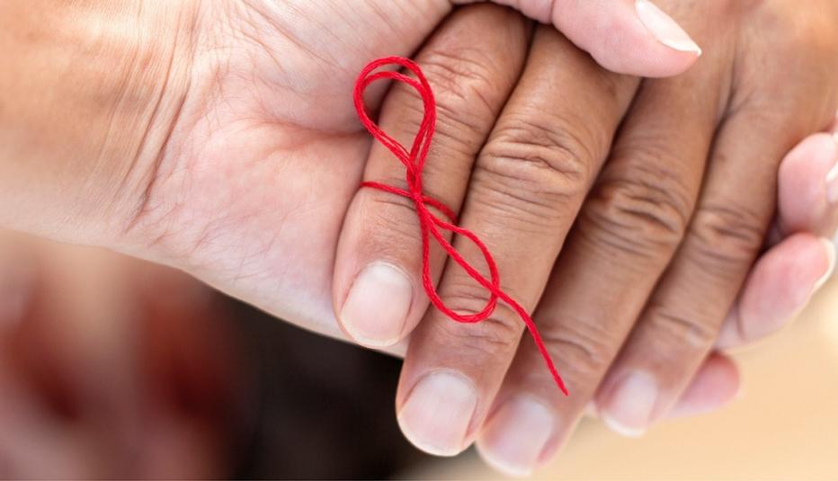 Close up of a hand with a red bow made of string tied to one finger