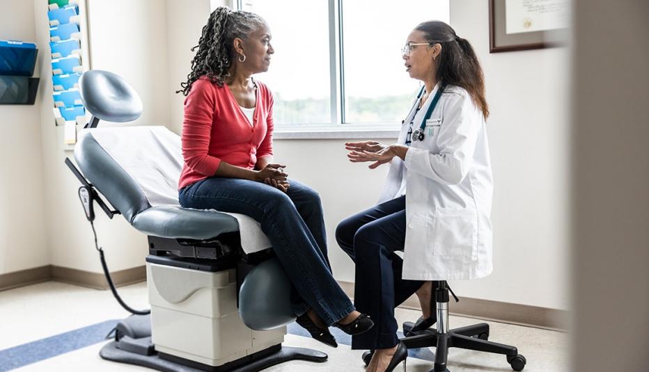Female doctor talking with senior woman in exam room