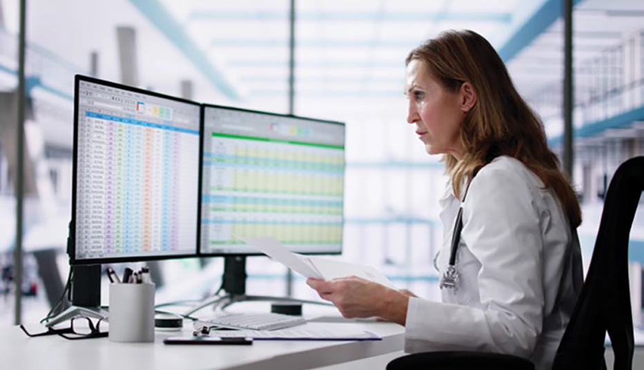 doctor in front of 2 computer screens