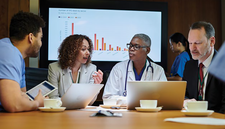 1472298952 group of workers at meeting with a large screen in background