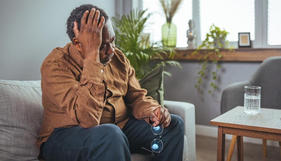 Older man sitting down with a headache