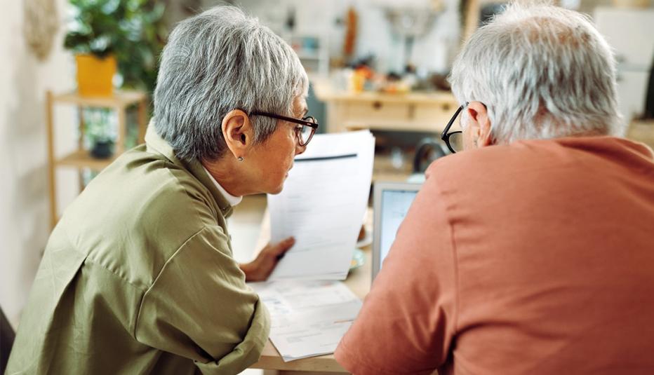 Work Requirements Will Tangle Older Adults in Red Tape Two older adults looking at a laptop and paperwork at the dinning room table.