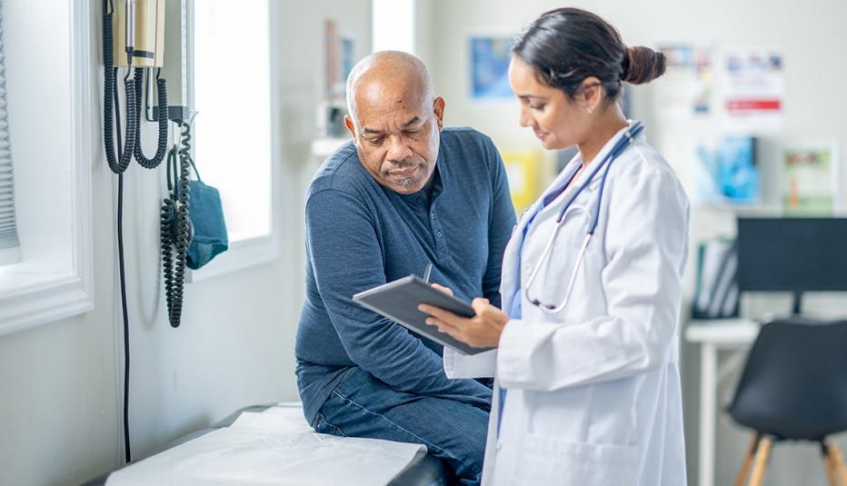 Premium Tax Credits Protect Affordability of Marketplace Health Coverage for Adults Ages 50 to 64 A senior gentleman of African decent sits up on an exam table during a routine check-up. His female doctor is holding out a tablet as they review some recent test results together.