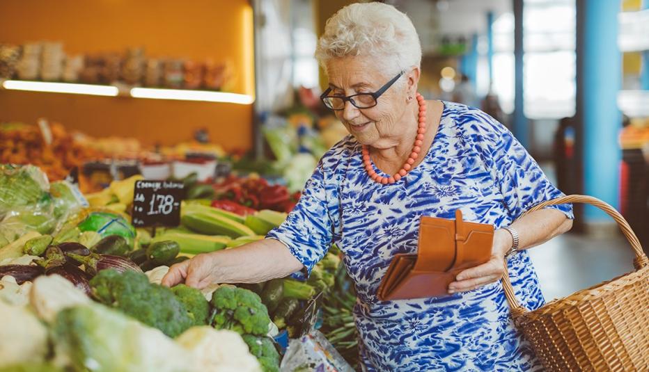 More Than 5 Million Older Adults Are Eligible for Both the Supplemental Nutrition Assistance Program (SNAP) and a Medicare Savings Program (MSP) Senior woman with grey hair and glasses shopping for vegetables in a market.