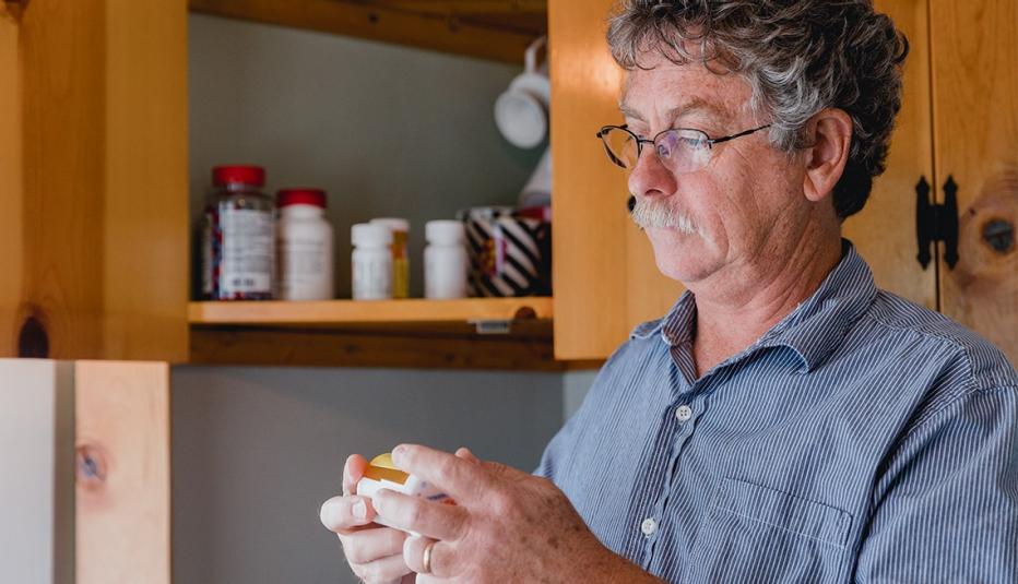 The Importance of Prescription Drugs to Midlife Medicaid Enrollees An elderly man taking medication in his kitchen.
