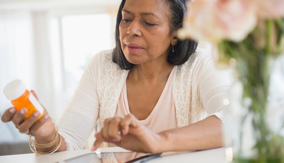 Older woman reading a prescription bottle