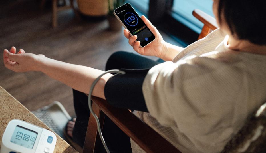 Mature woman examining blood pressure at home.