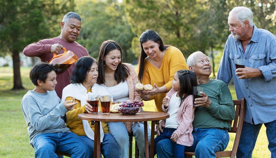 How Multiage Communities Can Connect Generations and Bring Benefits to People of All Ages A large multi-generation and extended family spending time together in the back yard, eating snacks and drinking refreshments. The group includes three grandchildren, three grandparents and an interracial Asian and Caucasian couple.