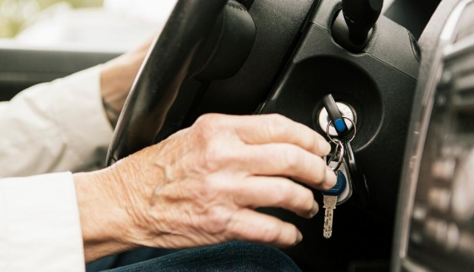 Older person's hand reaching for car keys