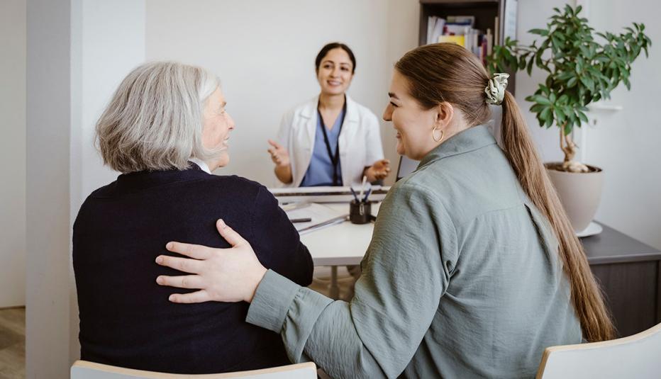 Older woman and caregiver talking to doctor