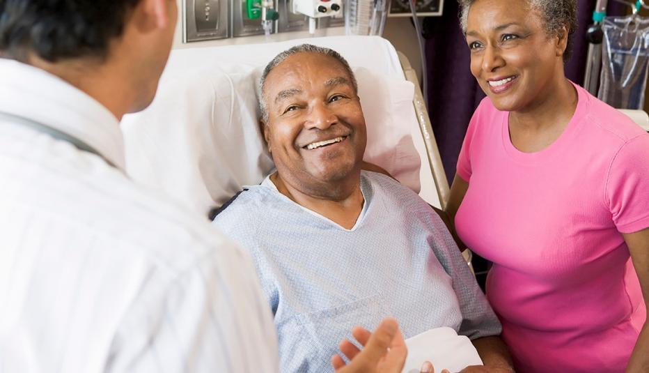 Senior couple talking with primary care doctor, smiling Senior couple talking with primary care doctor, smiling