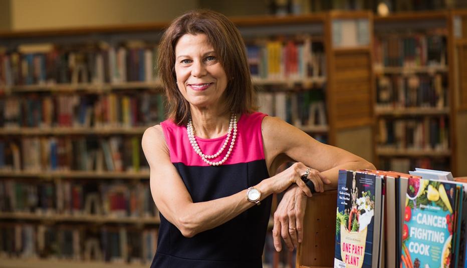 Sari Feldman leaning on a bookcase in one of the Cuyahoga County, Ohio libraries