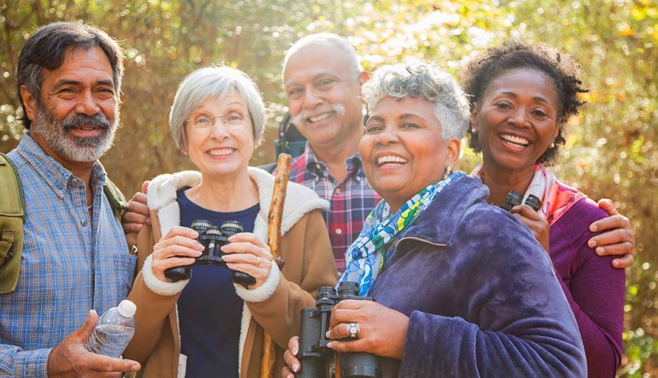 group of older friends hiking with binoculars