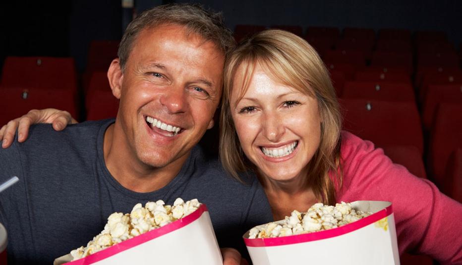 Mature couple eating popcorn at the movies Mature couple eating popcorn at the movies