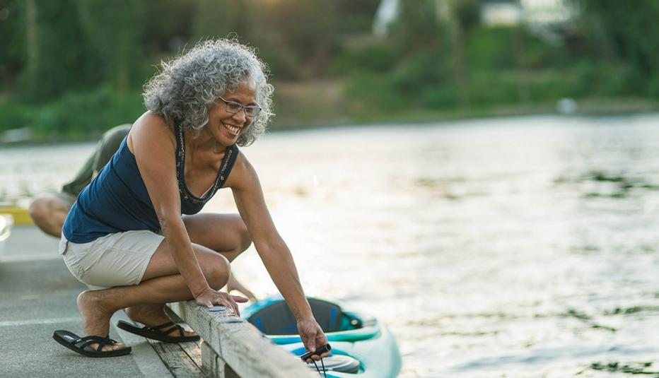 Woman on a pier putting kayak in the water 