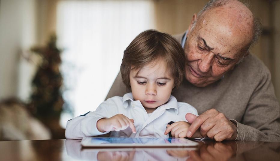 Grandfather and grandchild using a digital tablet