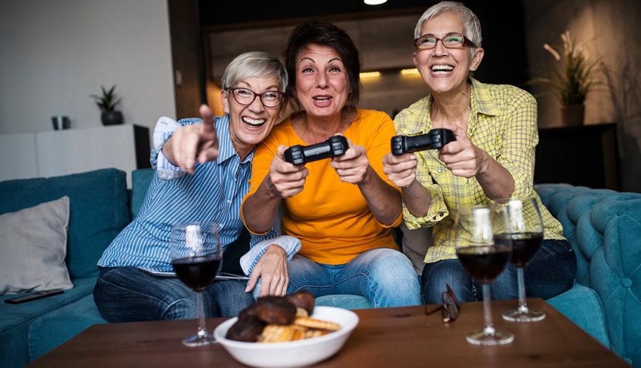 Senior women having great time together, playing a video game.