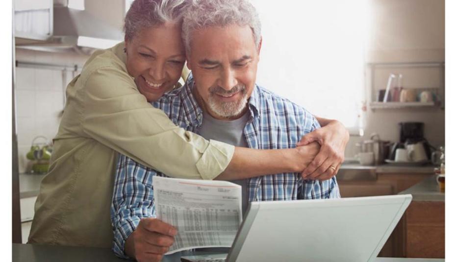 Older couple looking at their finances in front of a laptop
