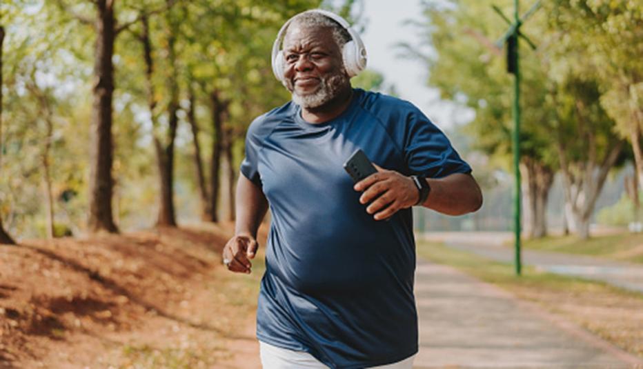 Senior man running and listening to music in public park