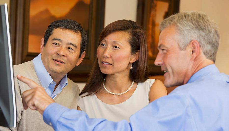 Couple looking at computer with their financial advisor