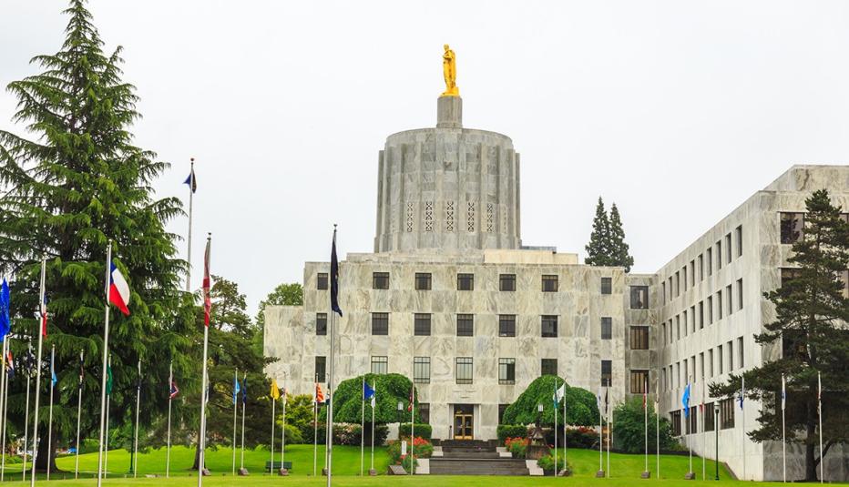 The Oregon State Capitol Building showing the dome, with a row of flags out front.