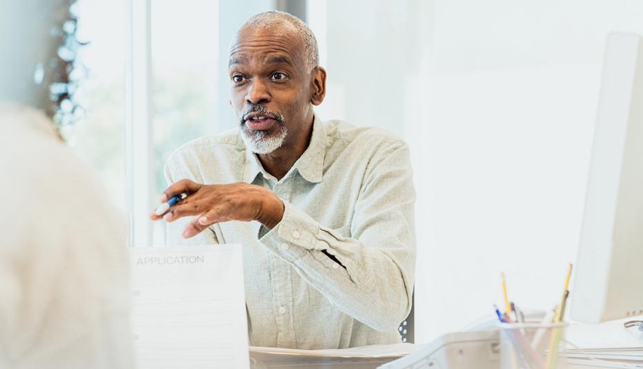 The mature adult male banker explains loan terms to an unrecognizable female.
