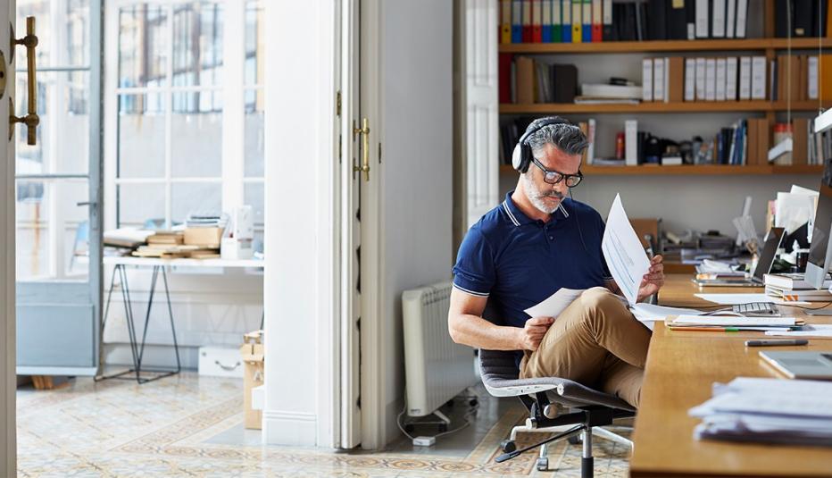 Mature businessman examining documents at desk in office