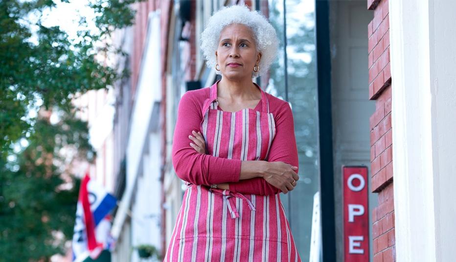 Concerned black store owner with white hair Looking Nervously down the Street