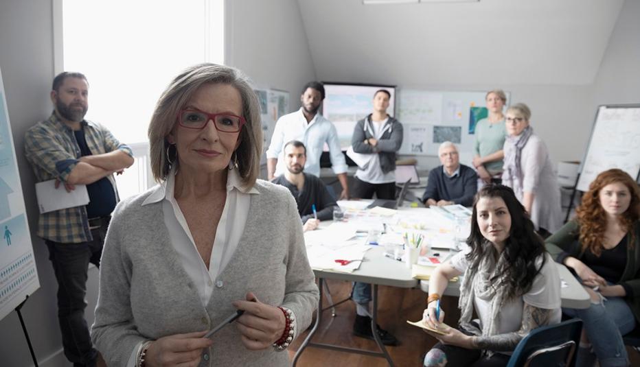 Portrait confident woman and volunteers working in office Portrait confident woman and volunteers working in office