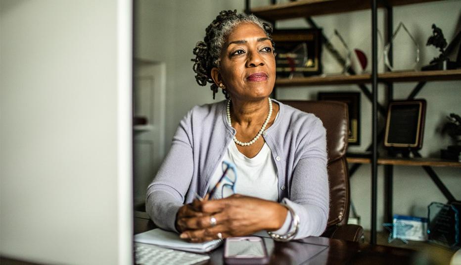 Portrait of senior woman at desktop computer in home office