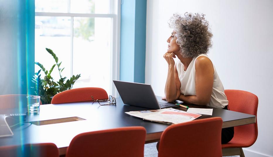 Middle aged woman looking out of the window in the boardroom