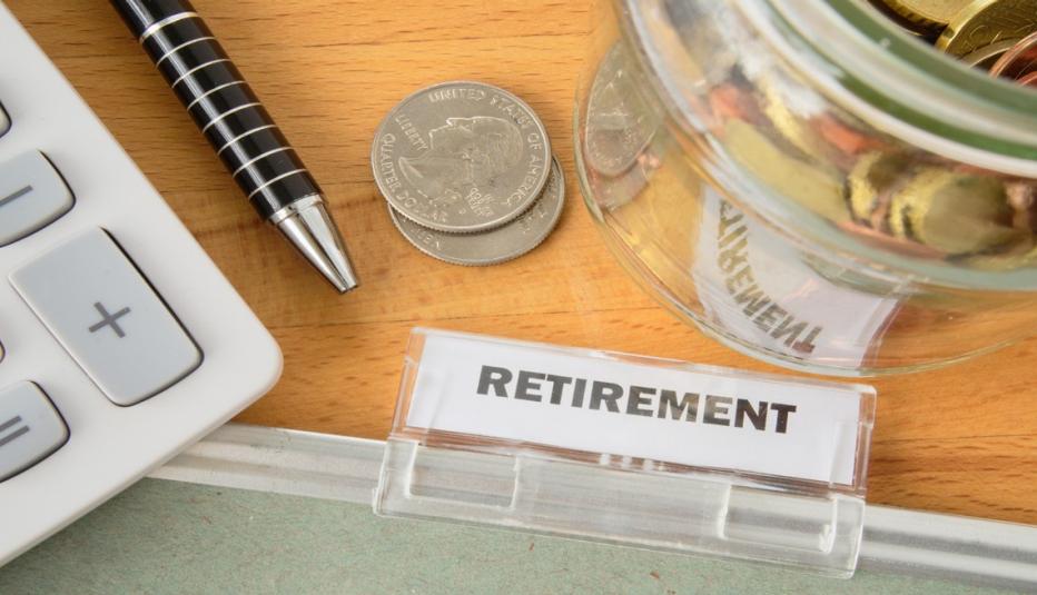 Retirement file with calculator, pen, coins and glass jar