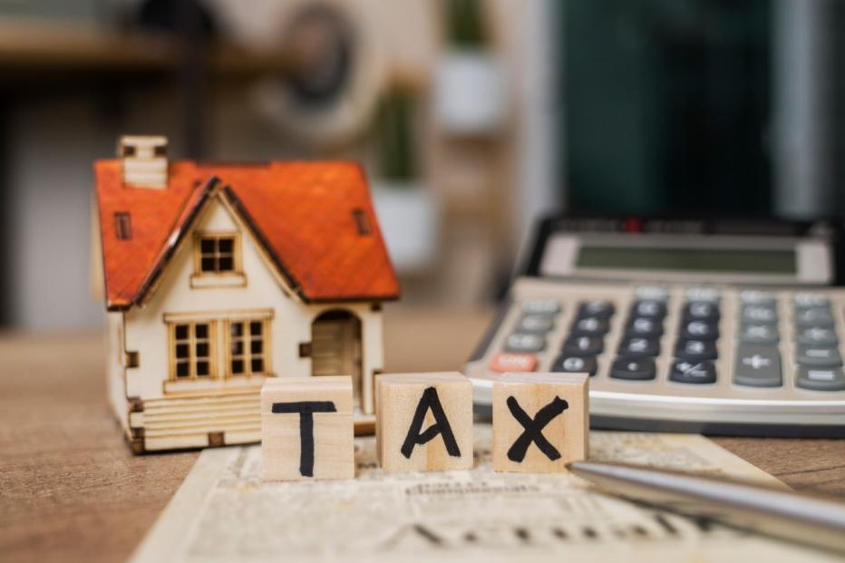 Tax Word on Wooden Block With Calculator and Tax Form