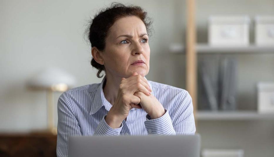 Concerned frustrated mature businesswoman sitting at laptop