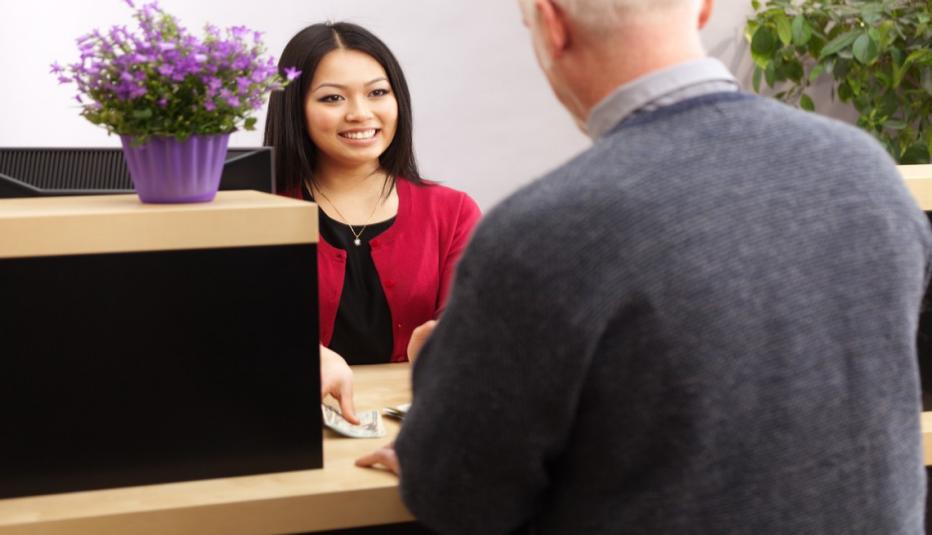 A bank customer making a transaction with a bank teller in a retail bank.