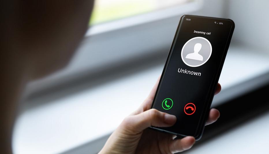 Woman holding mobile phone with incoming call from unknown caller