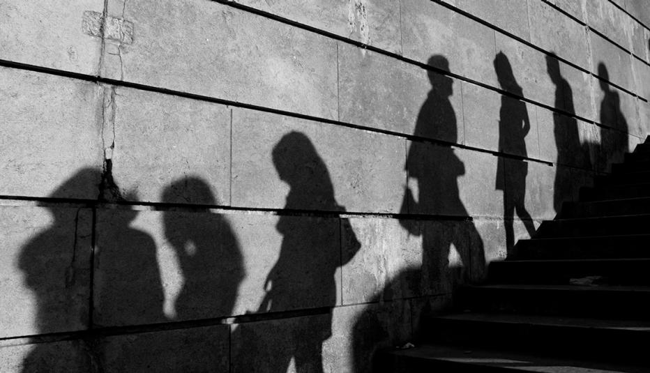 Silhouettes on the Wall Black and white image of silhouettes on a brick wall near a staircase in a city