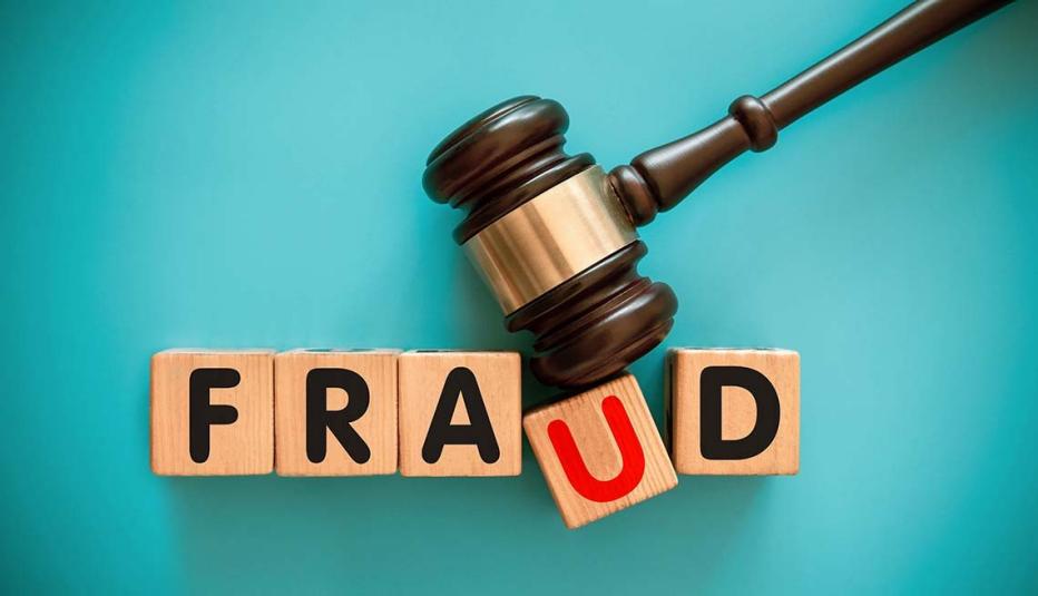 Gavel and wood block with FRAUD on blue background