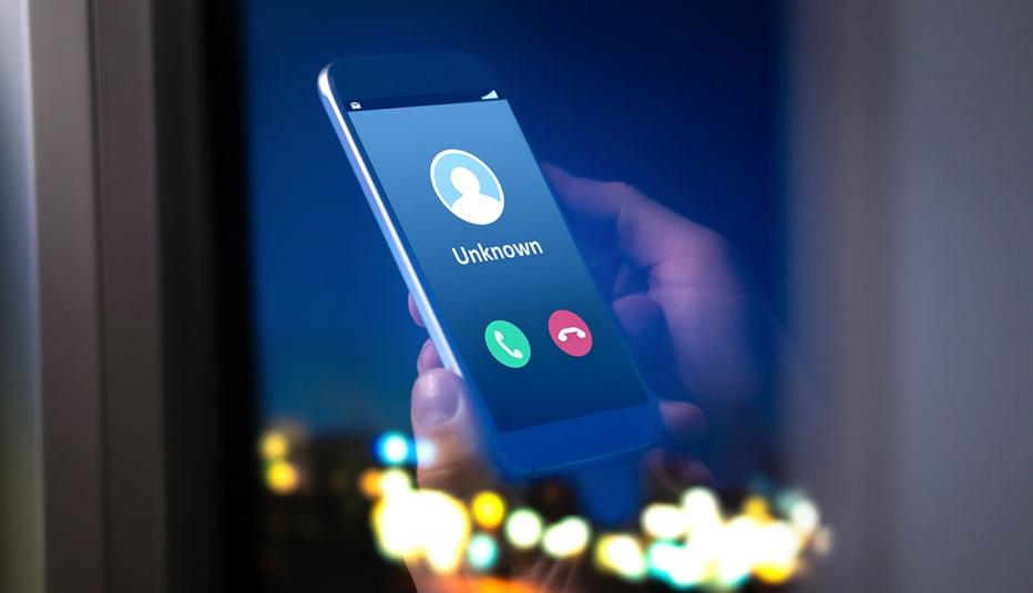 Close up of a hand holding a mobile phone that is getting a call from an unknown number Close up of a hand holding a mobile phone that is getting a call from an unknown number