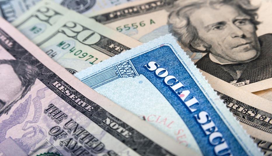 A pile of twenty dollar bills with a social security card on top