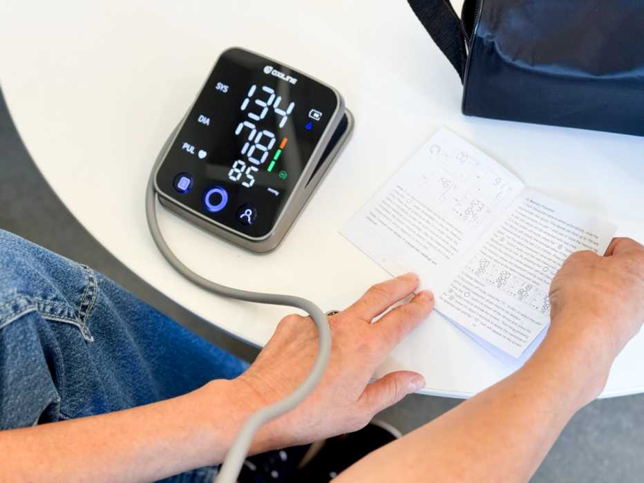A woman takes her blood pressure reading using an Oxiline blood pressure monitor. 