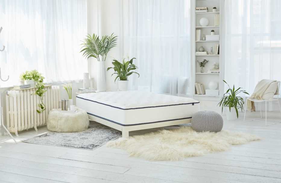 The WinkBeds GravityLux mattress in a bright white bedroom with plants