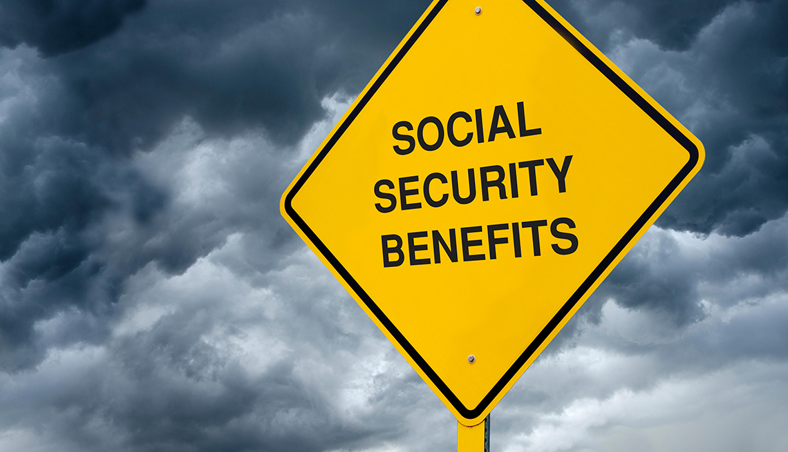 a caution sign in front of dark storm clouds says Social Security Benefits.